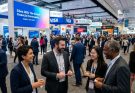 Financial professionals networking at Sibos 2026 inside the Miami Beach Convention Center, with exhibition stands and digital displays in the background