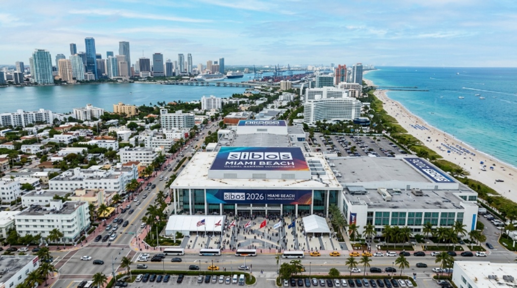 Aerial view of the Miami Beach Convention Center with the Miami skyline and ocean visible, hosting the Sibos 2026 global banking conference