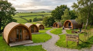 A scenic UK glamping site with wooden pods nestled in green countryside, representing the growing trend of Brits investing in camping land for income